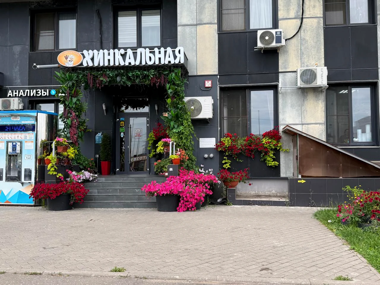 Вход в кафе «Хинкальная» с цветами и вывеской